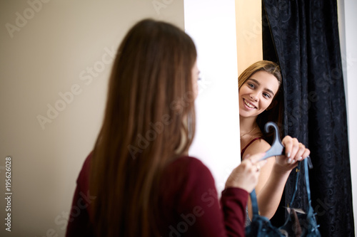 Vászonkép Beautiful young woman asking for a friends opinion in the fitting room of lingerie store