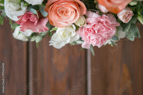 Delicate bouquet of roses  eustomams and carnations with eucalyptus branches on a dark wooden background
