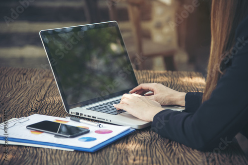 Side view of young smart female using laptop with sunlight. Working anywhere anytime anyplace.