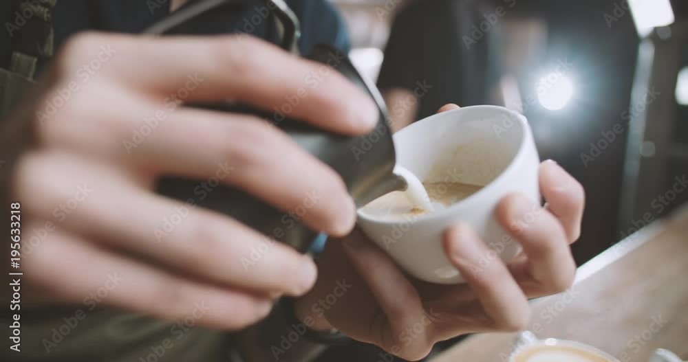Barista prepares a cappuccino Cup and draws a beautiful pattern of milk in the coffee shop Barista prepares a cappuccino Cup and draws a beautiful pattern of milk in the coffee shop