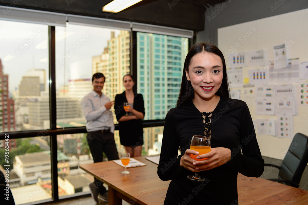 smile of beautiful business woman wear black dress and orange juice on hand at the office, celebrate for business success smile of beautiful business woman wear black dress and orange juice on hand at the office, celebrate for business success