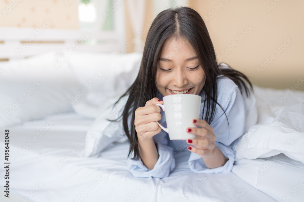 Happy Woman laying and have a breakfast coffee on bed after wake up. Happy Woman laying and have a breakfast coffee on bed after wake up.