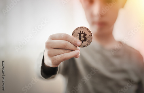 boy holding a golden Bitcoin