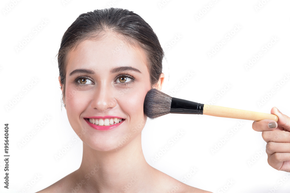 Young beautiful woman applying make-up by make-up artist isolated on white.
