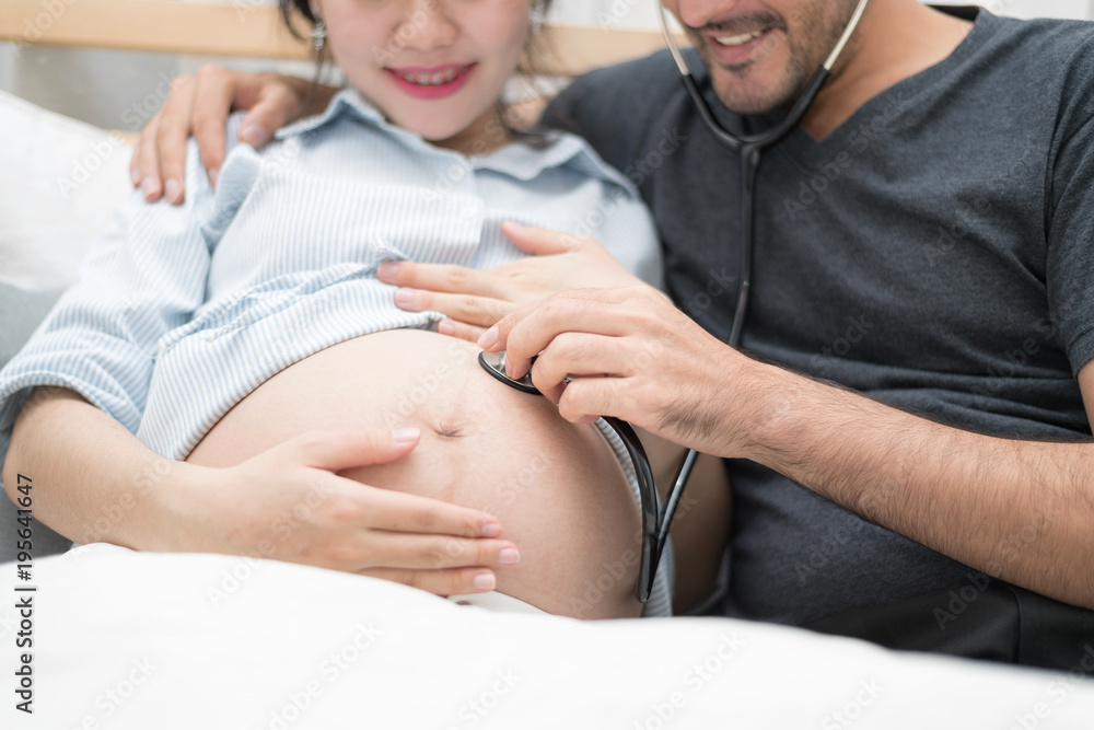 In Selective Focus Of Happy Family Checking New Baby In The Morning.Close Up Of A Beautiful Happy Pregnant Woman With Big Belly. Pregnancy And Motherhood Moment People And Expectation Concept. In Selective Focus Of Happy Family Checking New Baby In The Morning.Close Up Of A Beautiful Happy Pregnant Woman With Big Belly. Pregnancy And Motherhood Moment People And Expectation Concept.