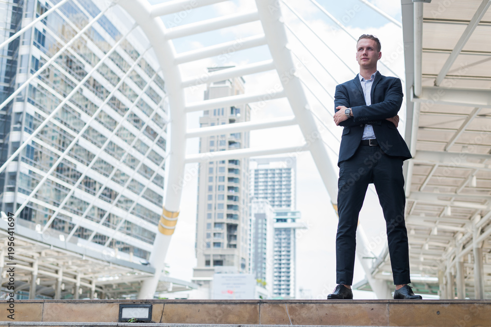 Caucasian businessman stand and smile, he looking forward and thinking for successful in career and mission. concept of winner and competition with copy space for text. Caucasian businessman stand and smile, he looking forward and thinking for successful in career and mission. concept of winner and competition with copy space for text.