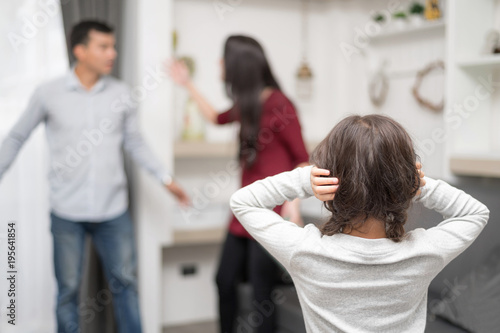 Domestic violence and Family conflict concept. Sadness little girl against blured of mother fighting father with quarrel at home.