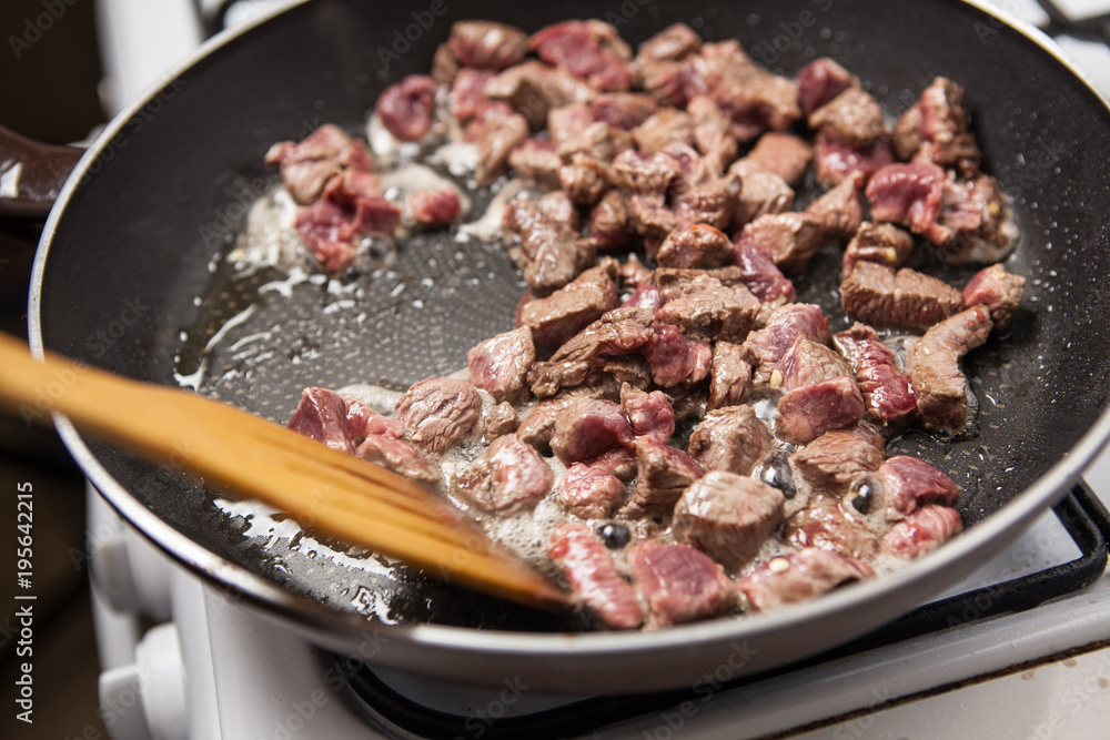 Pan with diced beef on stove. Close up. Pan with diced beef on stove. Close up.