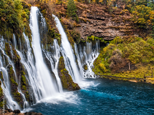 Picturesque waterfall cascade in autumn  surrounded by the moss and yellow bushes. Shot taken in October at McArthur-Burney Falls Memorial State Park  in Shasta County  Northern California.
