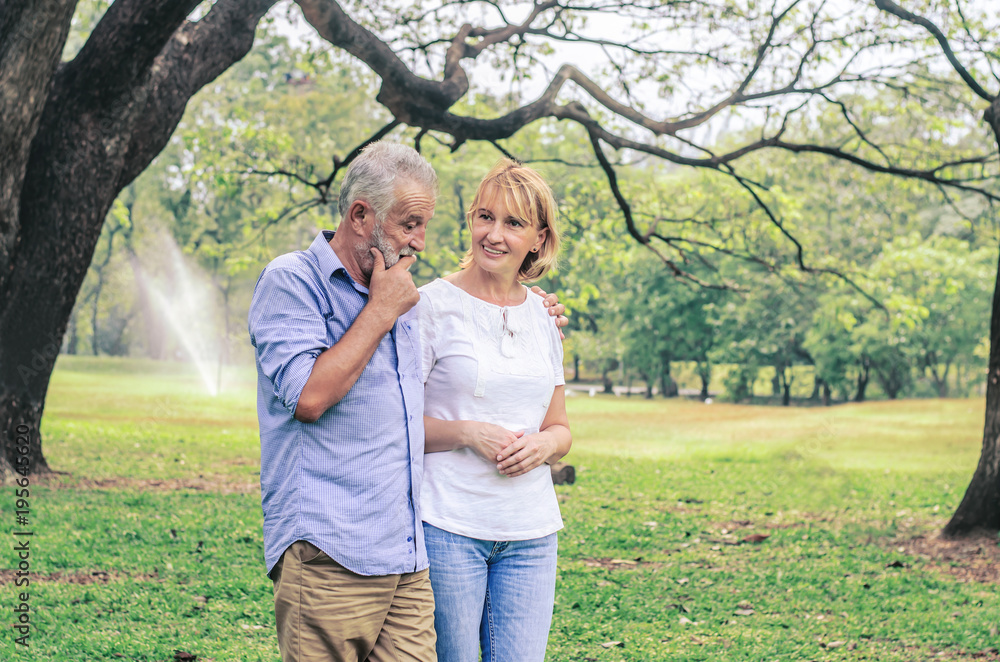 Happy senior couple together in a summer park, Being together and staying strong, happy life.