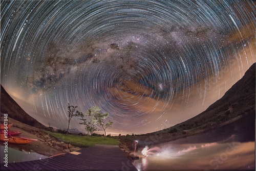 Milky way and star trails over dam