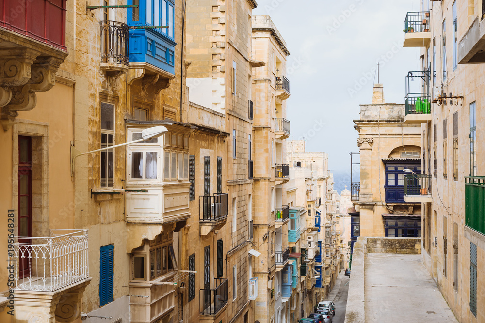 Valletta, Malta. Old Town street with traditional maltese balconies and sea view, City of Valletta