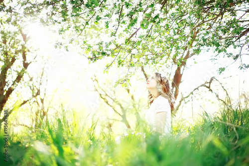 spring girl apple flowers, nature portrait of happy girl with long hair in blooming apple trees, freedom purity concept of happiness © kichigin19