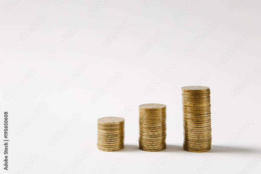 Close up three stacks of golden coins of different heights in a row isolated on white background. Concept of money business growth pyramid success earnings. Copy space for advertisement Price increase Close up three stacks of golden coins of different heights in a row isolated on white background. Concept of money business growth pyramid success earnings. Copy space for advertisement Price increase