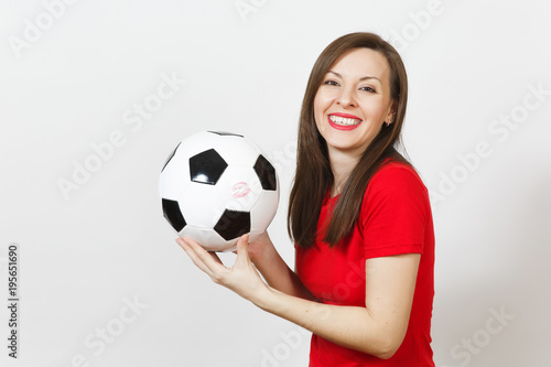 Beautiful European young cheerful happy woman  football fan or player in red uniform holding classic soccer ball isolated on white background. Sport  play football  health  healthy lifestyle concept.