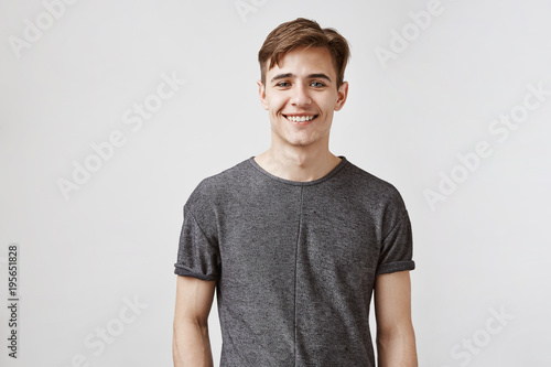 Handsome boyfriend smiles and looks to the camera. Young man is very glad his girlfriend got a promotion. He can not celebrate with her today, but they will arrange something on weekend. photo