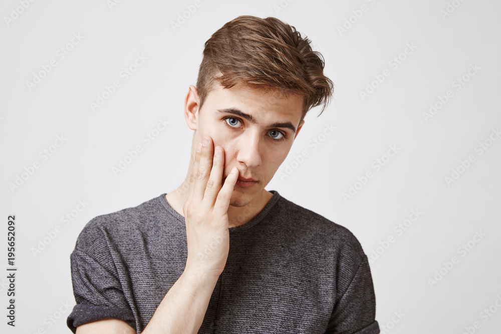 Close up picture of young brunette who looks tired and unhappy. How long girlfriend is going to stay in shower. Couple will be late if she do not hurry up. Maybe man should call friends and apologize Close up picture of young brunette who looks tired and unhappy. How long girlfriend is going to stay in shower. Couple will be late if she do not hurry up. Maybe man should call friends and apologize