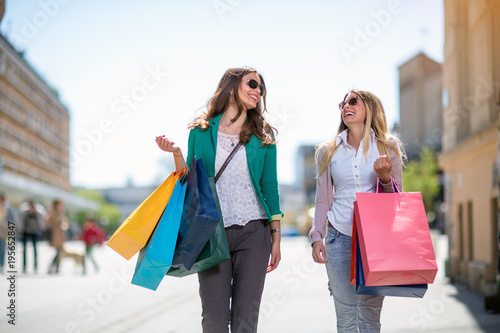 Beautiful girls with shopping bags walking.