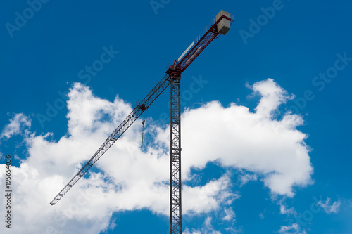 Construction crane bottom view in operation with sky clouds background