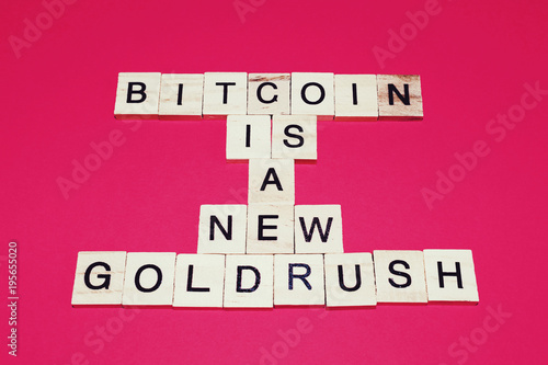Wooden blocks on a red background spelling words Bitcoin is a new goldrush