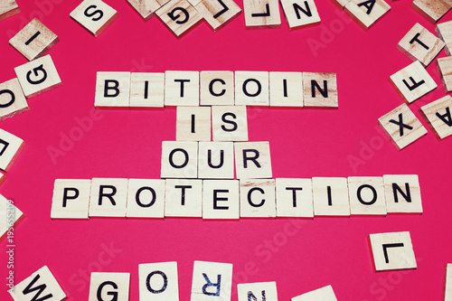 Wooden blocks on a red background spelling words Bitcoin is our Protection