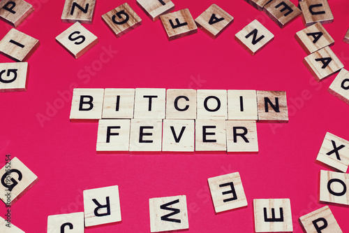 Wooden blocks on a red background spelling words Bitcoin fever