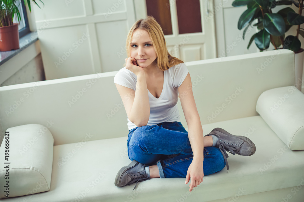 Close up Portrait of a beautiful smiling young blond woman sitting at home on a sofa and resting or relaxing. Close up Portrait of a beautiful smiling young blond woman sitting at home on a sofa and resting or relaxing.