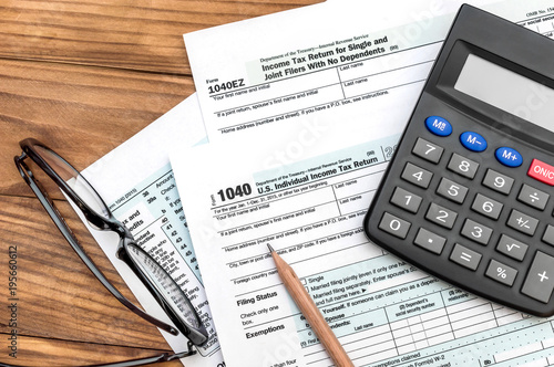 Tax forms with calculator, pencil and eyeglasses on the table. Top view. Business and tax concept.