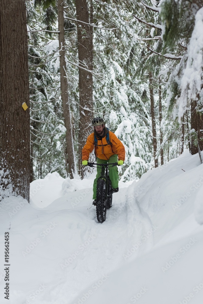 Man riding bicycle on a snowy landscape Man riding bicycle on a snowy landscape