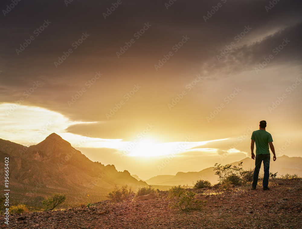 man watching golden sunset over mountains in nevada desert