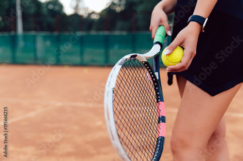 Tennis player. Close-up view of young woman ready to hit a tennis ball. Playing on the court.