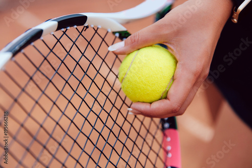 Female player's hand with tennis ball, preparing to serve during a match. Close-up view. © Maksym Azovtsev