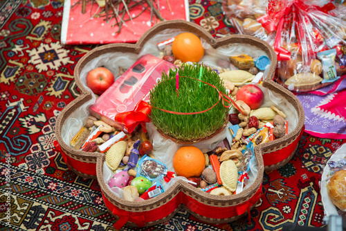 Novruz tray plate with Azerbaijan national pastry pakhlava and shekerbura purple silk scarf . Novruz copper tray plate with Azerbaijan national pastry pakhlava and shekerbura and green semeni © adilcelebiyev