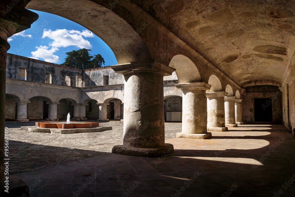 Under the arches of the courtyard with fontain of Capuchins Monastery in Antigua de Guatemala, Guatemala
