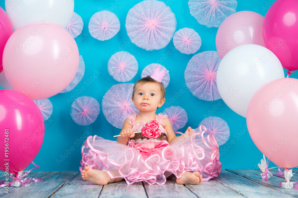 Fototapeta premium Funny child with a lollipop in the shape of a heart, happy little girl.