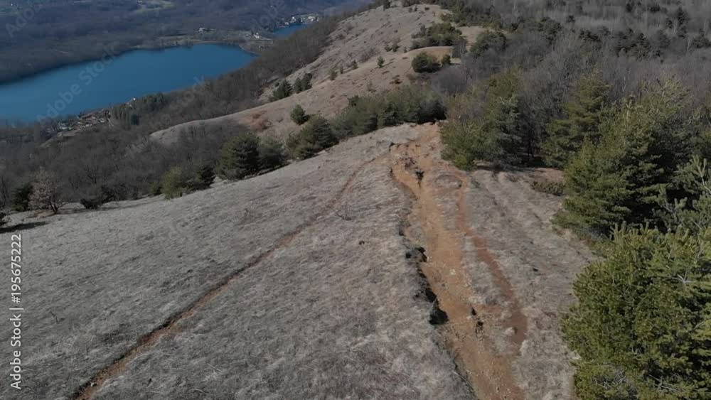 Aerial: drone flying over forest valley lake, aerial view of snow capped mountain range on the Alps, clear blue sky, Turin, Italy. Aerial: drone flying over forest valley lake, aerial view of snow capped mountain range on the Alps, clear blue sky, Turin, Italy.