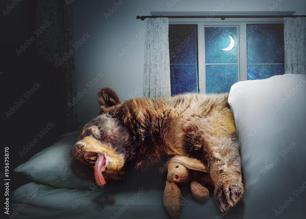 Fototapeta premium Zabawny niedźwiedź czarny śpi w łóżku