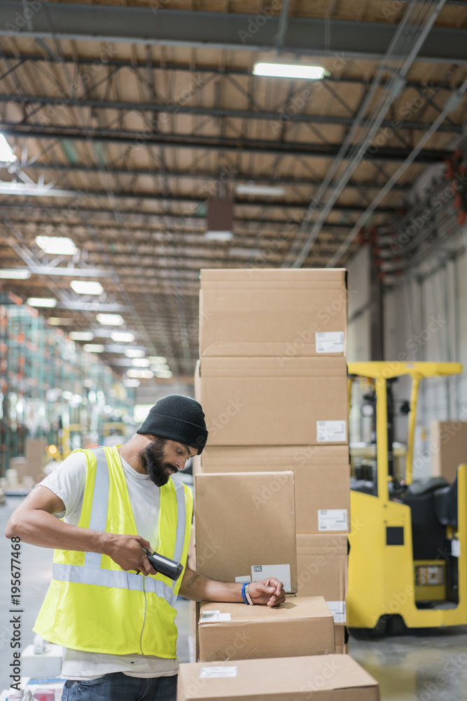 Warehouse worker using hand held scanner Warehouse worker using hand held scanner