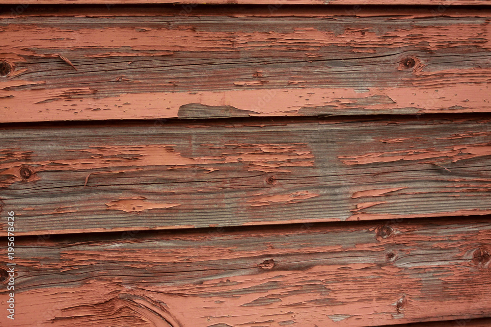 Flaking, red paint on an old wooden wall Flaking, red paint on an old wooden wall