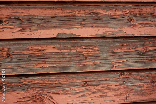 Flaking, red paint on an old wooden wall