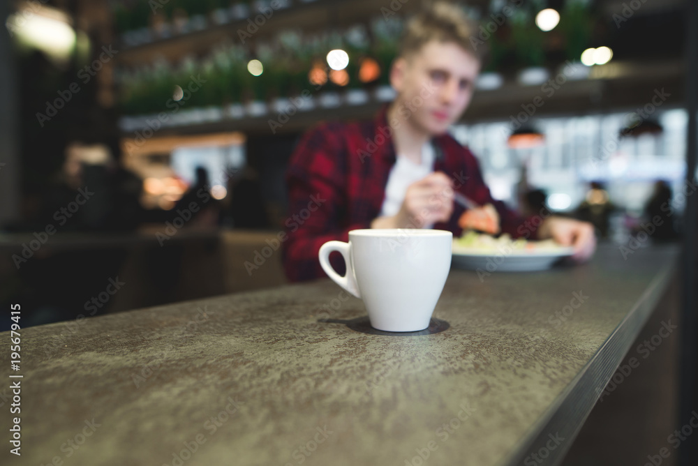 A cup of hot drink on the background of a person who eats a restaurant A cup of hot drink on the background of a person who eats a restaurant
