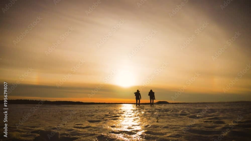 The Silhouette of two men walking on the sunrise with Backpacks. Tourists take photos while traveling. Travel concept. The Silhouette of two men walking on the sunrise with Backpacks. Tourists take photos while traveling. Travel concept.