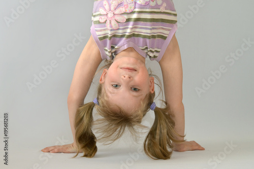 Little girl standing on her hands.