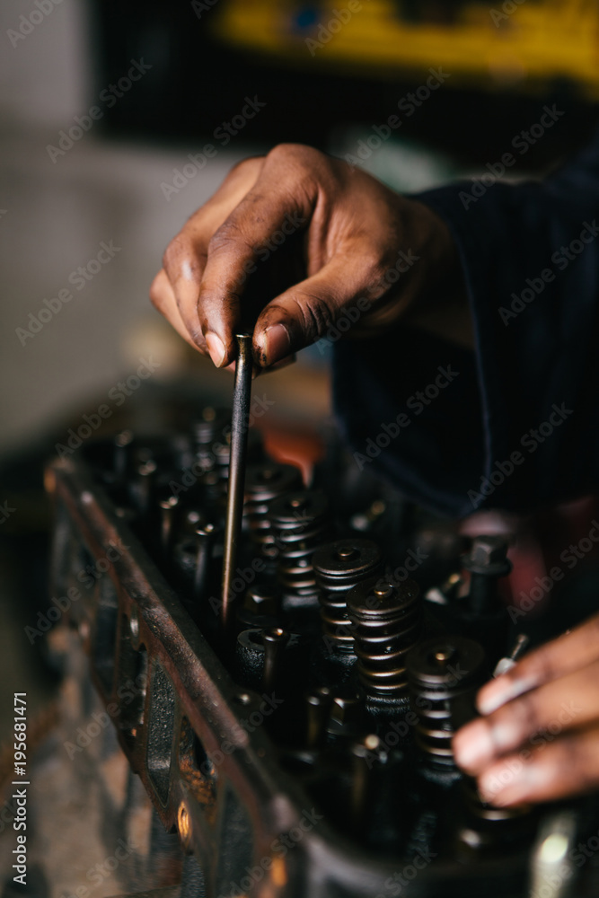 Mechanic fixing an engine for a head gasket repair in a garage. Mechanic fixing an engine for a head gasket repair in a garage.