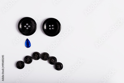 A sad smiley of buttons on a white background.