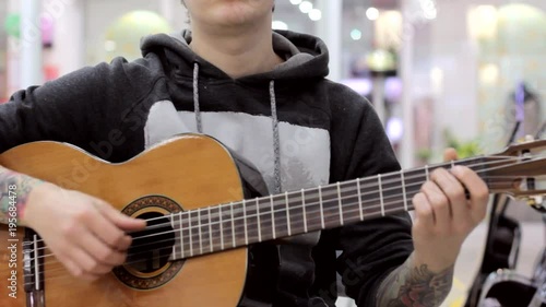 The guy plays a classical guitar in a music store, a musical mood, classical music