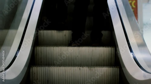 Low section of businessman going up the escalator