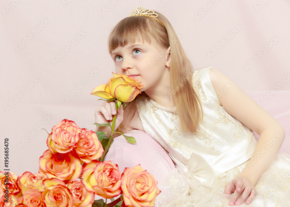 Girl sits next to a bouquet of flowers. Girl sits next to a bouquet of flowers.