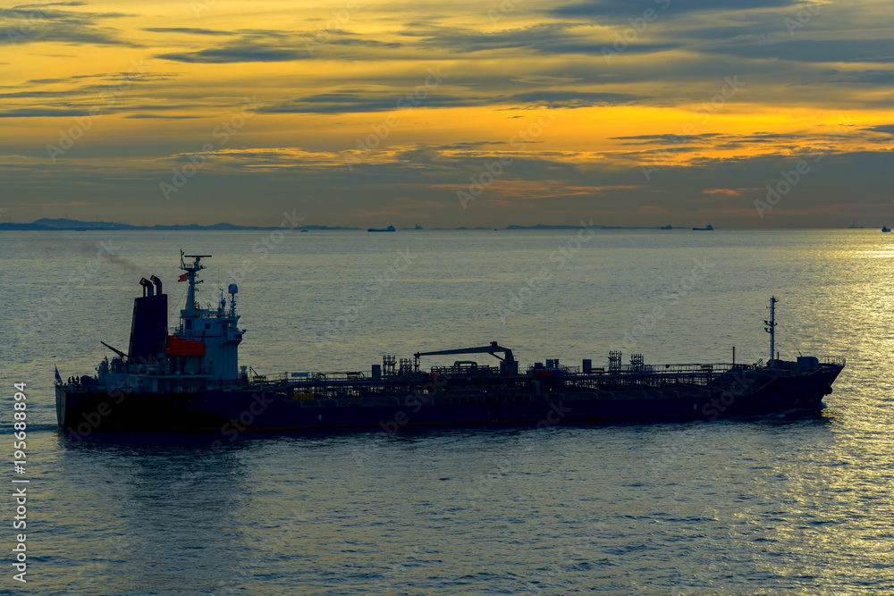 Silhouette of a tanker at sunset in sea.