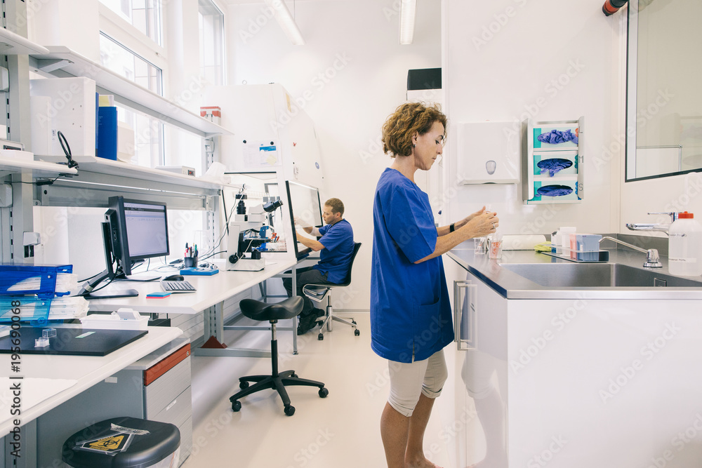 IVF Lab - Profile of Male and Female Lab Technicians at Work IVF Lab - Profile of Male and Female Lab Technicians at Work